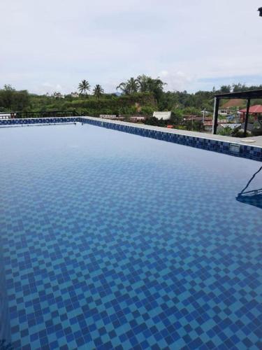 una gran piscina con azulejos azules. en Pakoan Indah Hotel Bukittinggi en Gadut