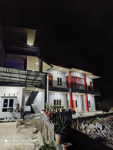 un gran edificio blanco con acentos rojos por la noche en Pakoan Indah Hotel Bukittinggi en Gadut