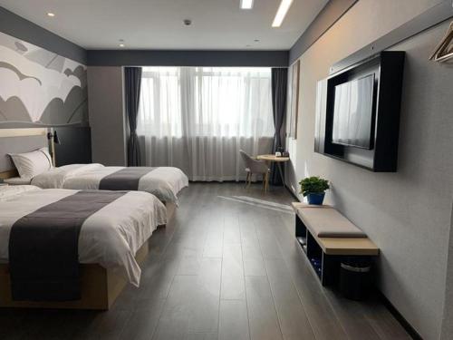 Habitación de hotel con 2 camas y TV de pantalla plana. en Thank Inn Ningxia Yinchuan Helan County Ningxia Jiaotong School, en Yinchuan