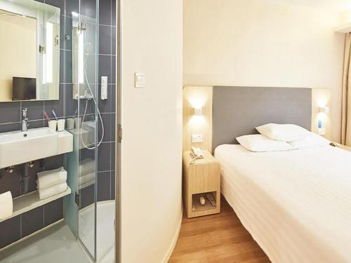 een slaapkamer met een bed en een badkamer met een wastafel bij Ji Hotel Gu'an Daxing International Airport in Gu'an