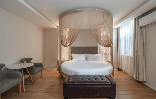 une chambre d'hôtel avec un lit, une table et des chaises dans l'établissement Ji Hotel Gu'an Daxing International Airport, à Gu'an