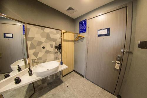 W łazience znajduje się umywalka i prysznic. w obiekcie Ji Hotel Hangzhou West Lake Hubin Erqing Building w mieście Hangzhou