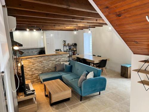 Lou Castel في Pomérols: غرفة معيشة مع أريكة زرقاء ومطبخ
