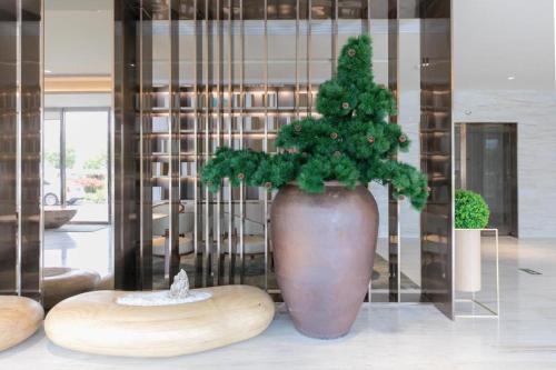 a large vase with a christmas tree in a room at JI Hotel Wenzhou South Railway Station in Louqiao
