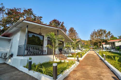 a house with a balcony and a dirt road at Amore Serenity Resort in Arambol