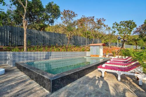 a swimming pool with a bench next to a fence at Amore Serenity Resort in Arambol
