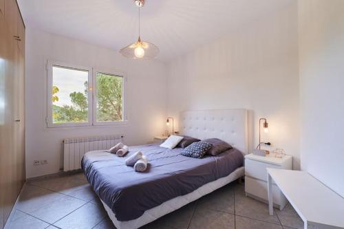 Un dormitorio con una cama grande con dos animales de peluche. en SeaHomes Vacations - VILLA ROYER, en Tordera