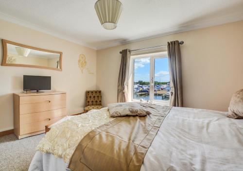 a bedroom with a bed and a television and a window at Marina Outlook in Horning