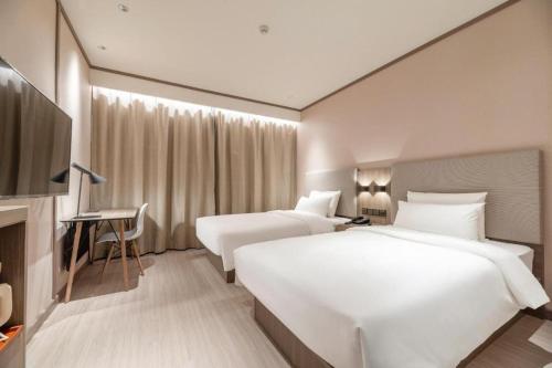 Ένα ή περισσότερα κρεβάτια σε δωμάτιο στο Hanting Hotel Heze Railway Station