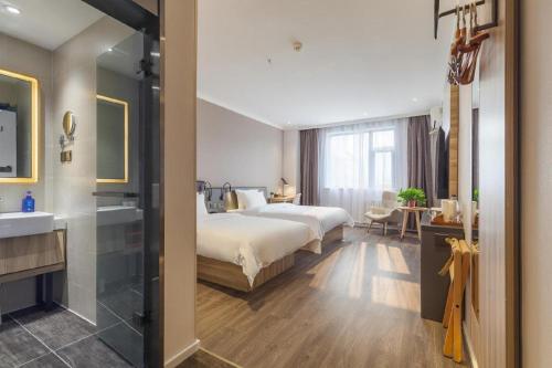 a hotel room with a bed and a sink at Hanting Premium Hotel Ji'nan Quancheng Road in Jinan