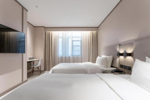 Un ou plusieurs lits dans un hébergement de l'établissement Hanting Hotel Ji'an Chengnan Administrative Center