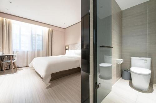 Habitación de hotel con cama y aseo en Hanting Hotel Ji'an Chengnan Administrative Center, en Ji'an