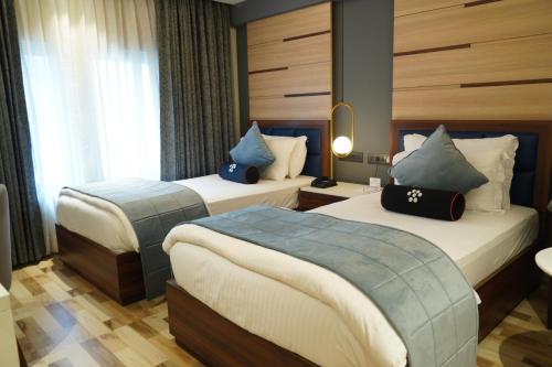 a hotel room with two beds and a window at Mastiff Hotel Dhanbad in Dhanbād