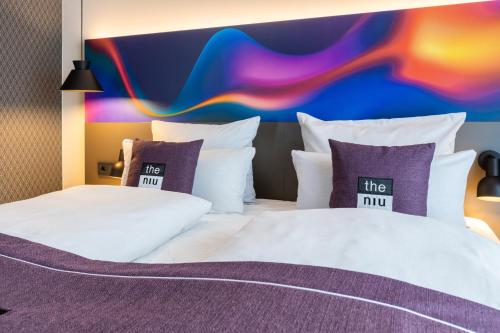 ein Hotelzimmer mit 2 Betten und einer farbenfrohen Wand in der Unterkunft the niu Wave - Apartments in Karlsruhe