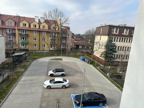 two cars parked in a parking lot with buildings at Apartament Łowca Snów in Chełm
