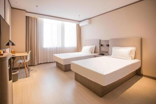 Un pat sau paturi într-o cameră la Hanting Hotel Baotou Baogang