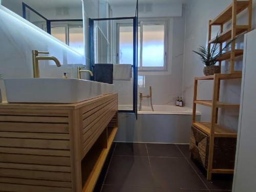 une salle de bain avec un lavabo et une baignoire dans l'établissement Cosy Vertigo apartment behind the hotel Martinez, à Cannes