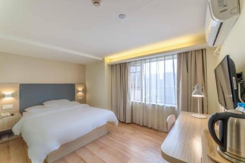 Een bed of bedden in een kamer bij Hanting Hotel Wuhan MinHang Xiaoqu