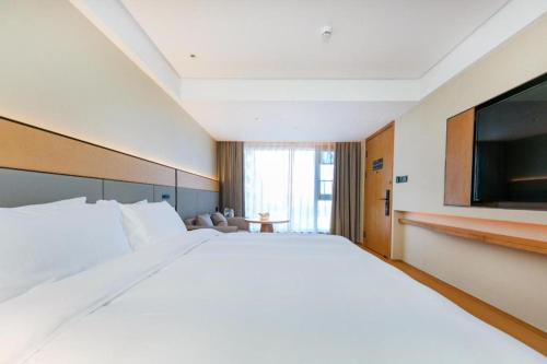 Кровать или кровати в номере Ji Hotel Wenzhou Economic Development Zone Binhai Park