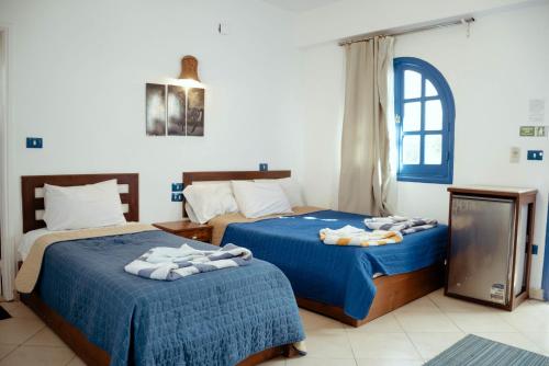 Sea Horse Hotel Dahab في دهب: سريرين في غرفة الفندق عليها مناشف