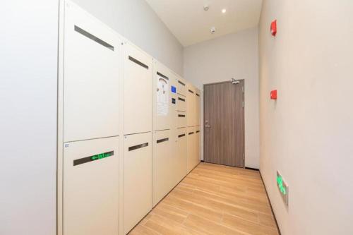 a locker room with white lockers and a door at Hanting Hotel Wenzhou Yongjia Station in Wenzhou