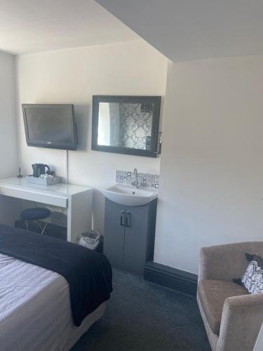 1 dormitorio con cama, lavamanos y sofá en Idan House, en Llanberis