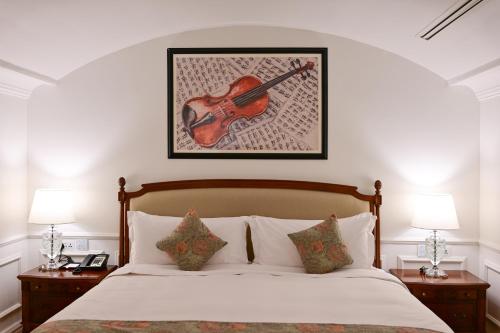 a room with a bed with a violin on the wall at 21 High Street Residence By The Torch in Doha