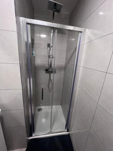 W łazience znajduje się prysznic ze szklanymi drzwiami. w obiekcie Guest house w Dublinie
