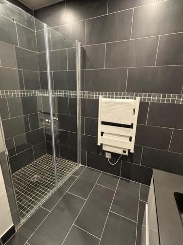 uma casa de banho com um chuveiro e uma porta de vidro em Relax 1 bedroom apartment - EG01 em Enghien-les-Bains