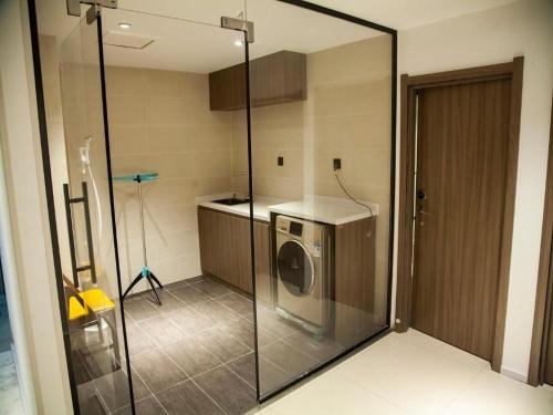 a washer and dryer in a kitchen with a glass door at Hanting Premium Hotel Youjia Dengfeng Terminal in Dengfeng
