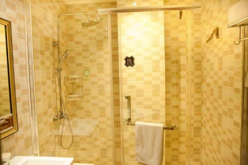 a bathroom with a shower with a glass door at Hi Inn Shanghai Dongan Road Metro Station in Shanghai