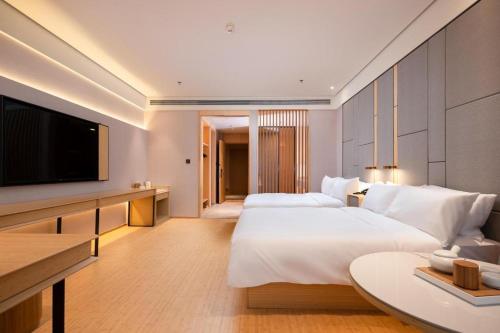 Een bed of bedden in een kamer bij Ji Hotel Nantong Railway Station