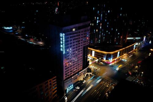 a night view of a tall building with lights on at Ji Hotel Harbin Zhongyang Da Street Suofeiya in Harbin