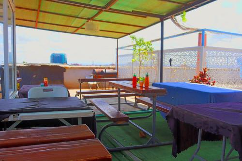 an outdoor patio with tables and chairs and a roof at DefiniteHomes1 - Fully furnished studio with a rooftop restaurant near JKIA Airport, Downtown Nairobi in Nairobi
