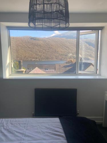 a bedroom with a large window with a view at Idan House in Llanberis