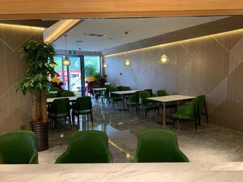 a restaurant with green chairs and tables in a room at Starway Hotel Lanzhou Matan Lao Street in Lanzhou