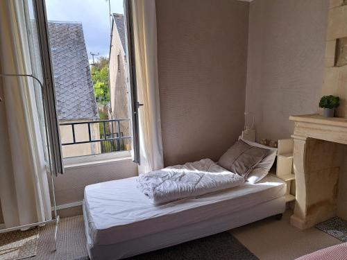 a bed in a room with a large window at La petite bajocasse in Bayeux