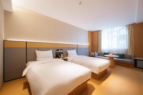 Un pat sau paturi într-o cameră la Ji Hotel Dalian Xi'an Road