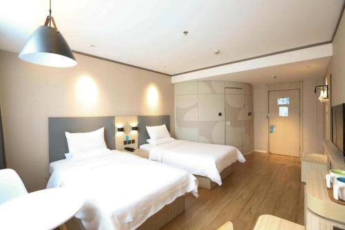Un pat sau paturi într-o cameră la Hanting Hotel Jinan Jingshi Road Qianfoshan