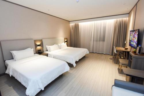Hanting Hotel Xuancheng Jing County tesisinde bir odada yatak veya yataklar