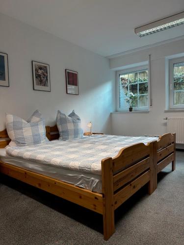 a large wooden bed in a room with two windows at City-Residenz Ge-Buer in Gelsenkirchen