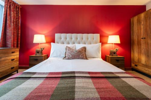 ein Schlafzimmer mit einem weißen Bett mit roten Wänden in der Unterkunft The Bull on the Green in Newick