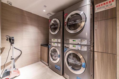 two washing machines in a laundry room with a vacuum at Hanting Hotel Wuhan Jiedaokou Metro Station in Han-yang-hsien