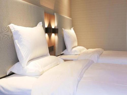 Łóżko lub łóżka w pokoju w obiekcie Hanting Hotel Kunshan South Railway Station