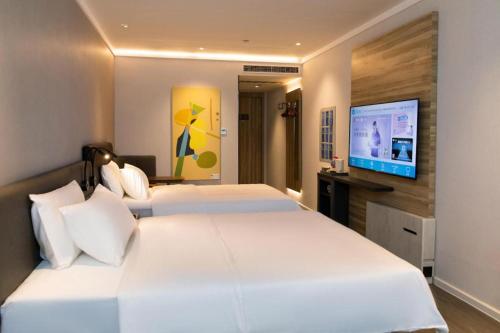 Hanting Premiun Hotel Handan New Century Plaza tesisinde bir odada yatak veya yataklar