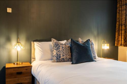 Un dormitorio con una cama con almohadas. en The Bull on the Green en Newick