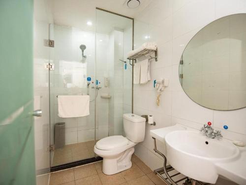 a bathroom with a toilet and a sink and a mirror at Hanting Hotel Jiaozhou Jiaodong International Airport in Madian