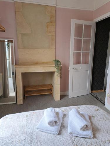 a bedroom with a bed with two towels on it at La petite bajocasse in Bayeux