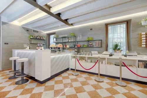 a restaurant with a counter with stools in a room at Hotel Fontana Verona in Verona