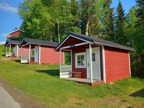 Ristafallets Camping في Nyland: صف من المباني الحمراء على ميدان عشبي